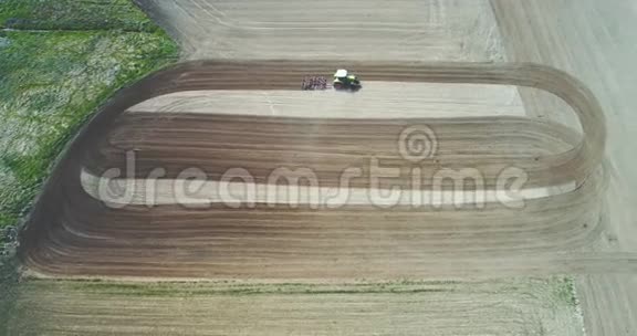 拖拉机耕田在麦田干活的农民视频的预览图