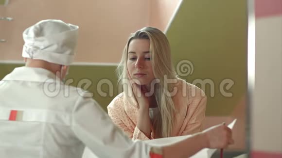 年轻女医生与女病人在医院病房交谈视频的预览图