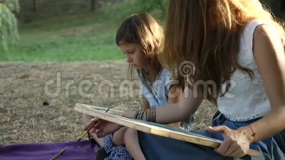 有女儿在公园里用水彩画画画的女人视频的预览图