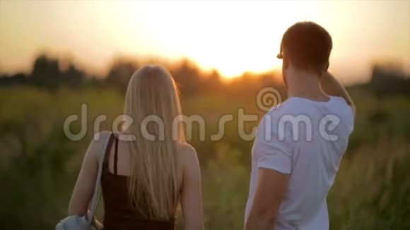 日落的浪漫情侣两个人在日落或日出时相爱男子和妇女视频的预览图
