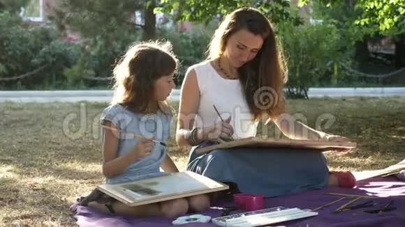 有女儿在公园里用水彩画画画的女人视频的预览图