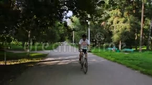 阳光明媚的一天一个人在公园里骑自行车视频的预览图