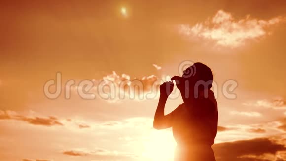 女人跪着祈祷女孩在日落时双手交叉在生活方式祈祷剪影中慢动作视频女孩视频的预览图
