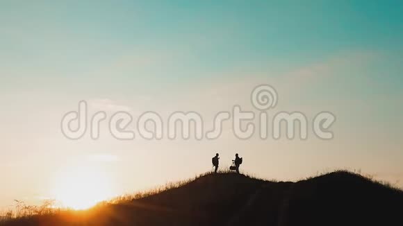 两个男子游客徒步旅行者剪影去山上日落旅游慢动作视频旅行成功的年轻人视频的预览图