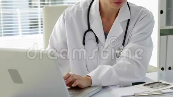 医生在笔记本电脑上打字对着相机微笑视频的预览图