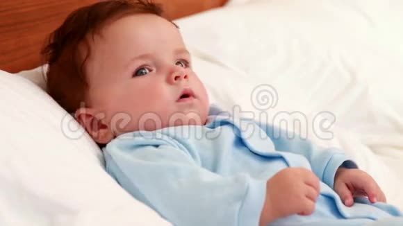 穿着蓝色婴儿裤的男孩躺在床上视频的预览图