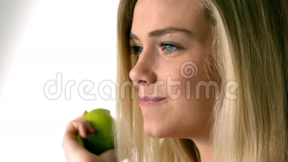 金发美女在吃绿色苹果视频的预览图