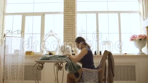 年轻的服装设计师和女裁缝工在裁缝工作室里用缝纫机工作视频的预览图