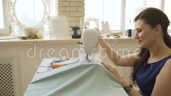 年轻的服装设计师和女裁缝工在裁缝工作室里用缝纫机工作视频的预览图