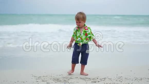 阳光明媚的一天一个孩子在沙滩上玩耍视频的预览图
