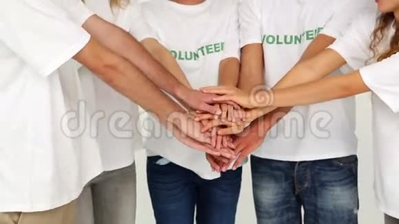 一队志愿者把手放在一起视频的预览图