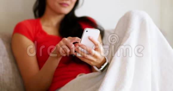 幸福的女人在客厅里用手机视频的预览图
