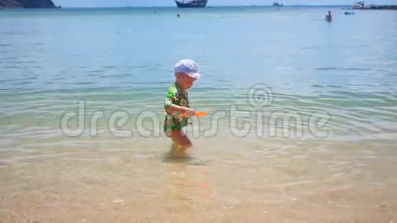 一个孩子在阳光明媚的沙滩上玩耍视频的预览图