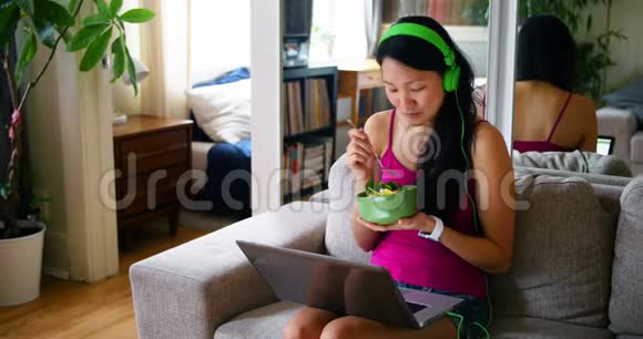 女人在吃早餐的时候用笔记本电脑视频的预览图
