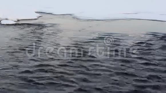 冬季雪中河水的水流视频的预览图