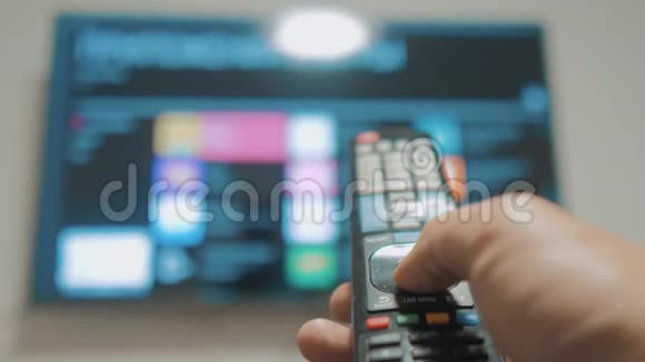 智能电视与应用程序和手男性手握遥控器关闭智能电视男人手控制电视生活方式视频的预览图