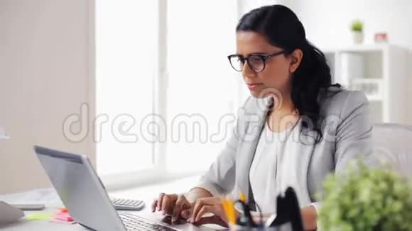 办公室里穿着笔记本电脑的女商人视频的预览图