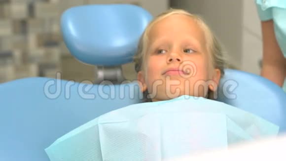 坐在牙医办公室的小女孩视频的预览图