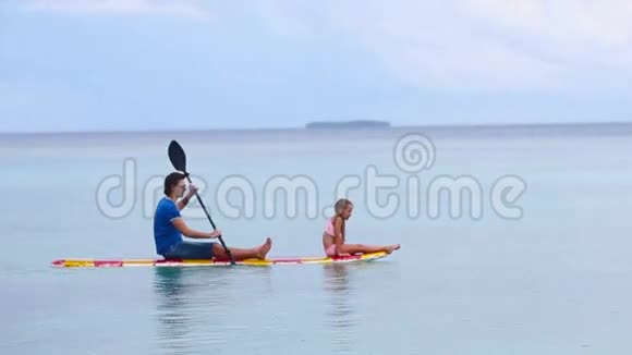 冲浪板上的小女孩和小爸爸视频的预览图