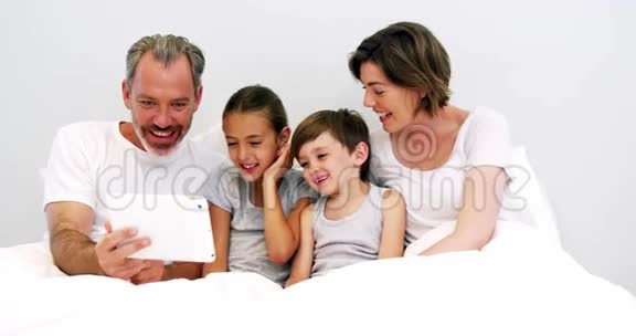 家庭在卧室里使用数字平板电脑视频的预览图
