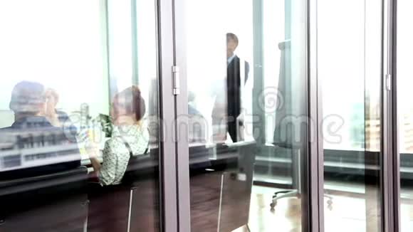 商务人士在玻璃墙后面开会视频的预览图