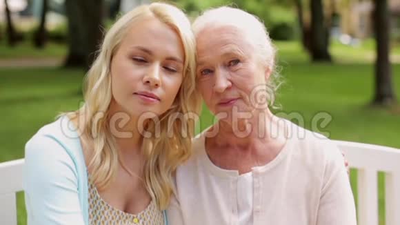 女儿和老母亲坐在公园长椅上视频的预览图