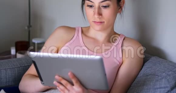 客厅4k沙发上用数码平板电脑的女人视频的预览图