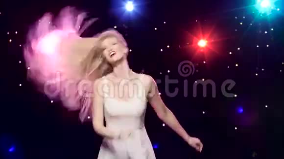 无忧无虑的女孩在迪斯科舞厅的灯光和闪闪发光的彩纸上跳舞视频的预览图