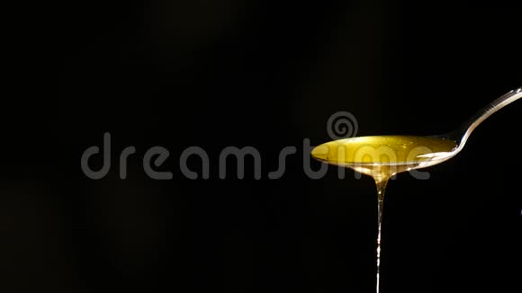 蜂蜜从勺子中流出背景是黑色视频的预览图