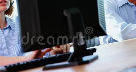 带耳机的男性高管在电脑上工作视频的预览图