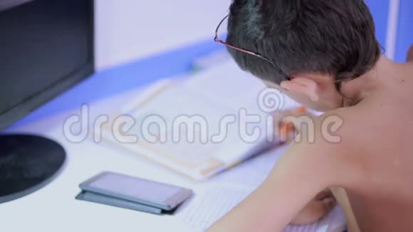 十几岁的男孩用手机做作业自然视频视频的预览图