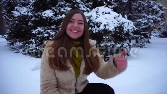 年轻女孩在冬天的背景上摆姿势视频的预览图