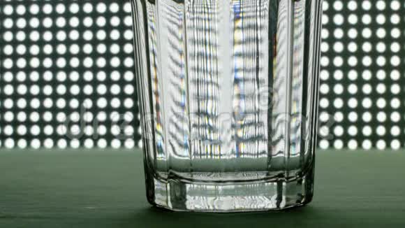 一片泡腾的止痛片落入玻璃杯中在彩色背景上溶解慢镜头的阿司匹林视频的预览图
