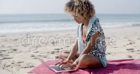 夏日海滩上有笔记本电脑的女人视频的预览图