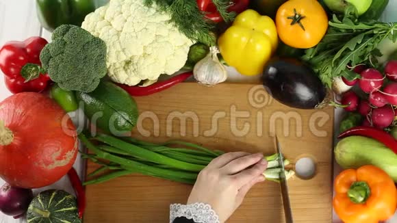 女人在新鲜蔬菜中切葱视频的预览图