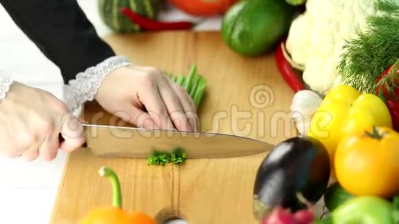 女人在新鲜蔬菜中切葱视频的预览图