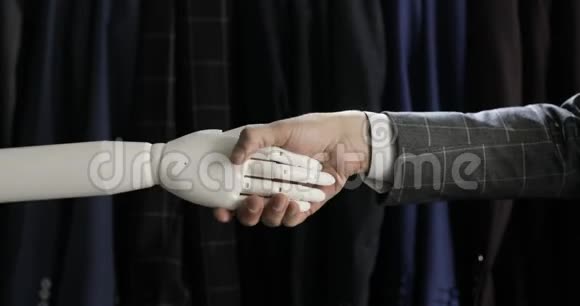 现代机器人技术一个人和一个机器人交流把一个塑料机械手臂按到机器人身上握手视频的预览图
