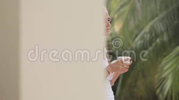 快乐的女人早上在露台上喝咖啡视频的预览图
