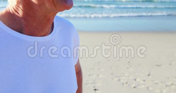微笑的老人站在海滩上视频的预览图
