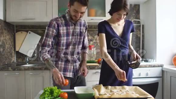 快乐的年轻夫妇在家的现代厨房做饭视频的预览图