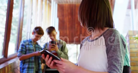 女生在走廊上使用手机视频的预览图