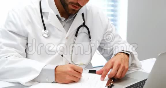 男医生在书桌上写剪贴板视频的预览图
