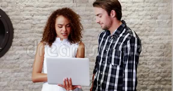 男性和女性高管讨论笔记本电脑视频的预览图