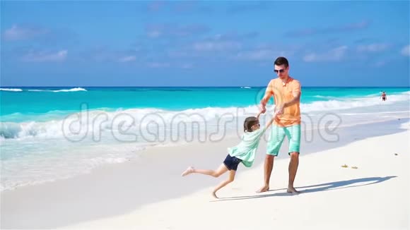 父亲和他可爱的小女儿在热带海滩视频的预览图