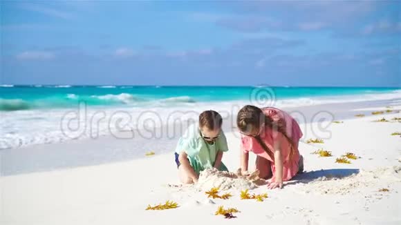 可爱的小孩在白色海滩上玩沙子视频的预览图