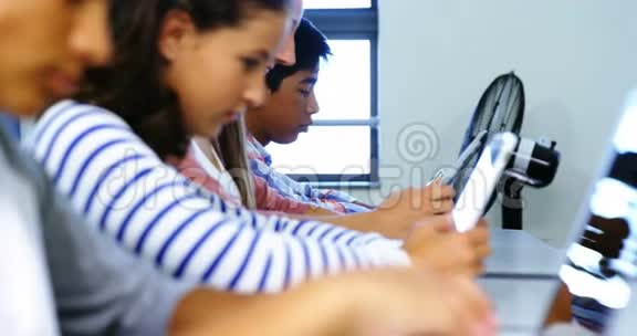 教室里使用数字平板电脑和笔记本电脑的学生视频的预览图