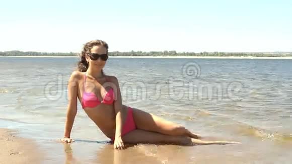 年轻女子在海滩上摆姿势视频的预览图