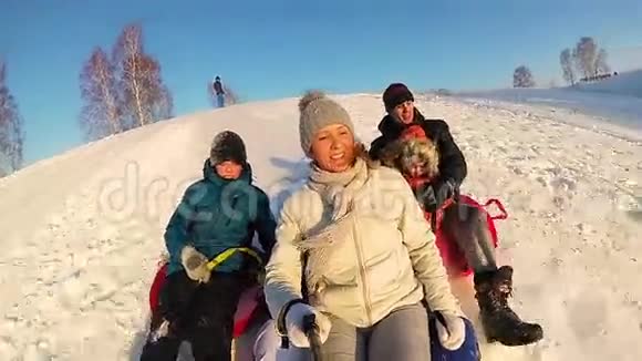 幸福的家庭乘坐和微笑的雪管在雪道上慢动作冬天的雪景户外运动视频的预览图