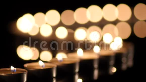 许多蜡烛在黑色背景上发光视频的预览图