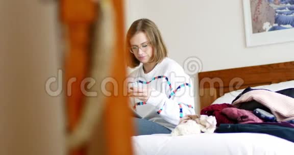 女人在卧室里用数码平板电脑和手机视频的预览图